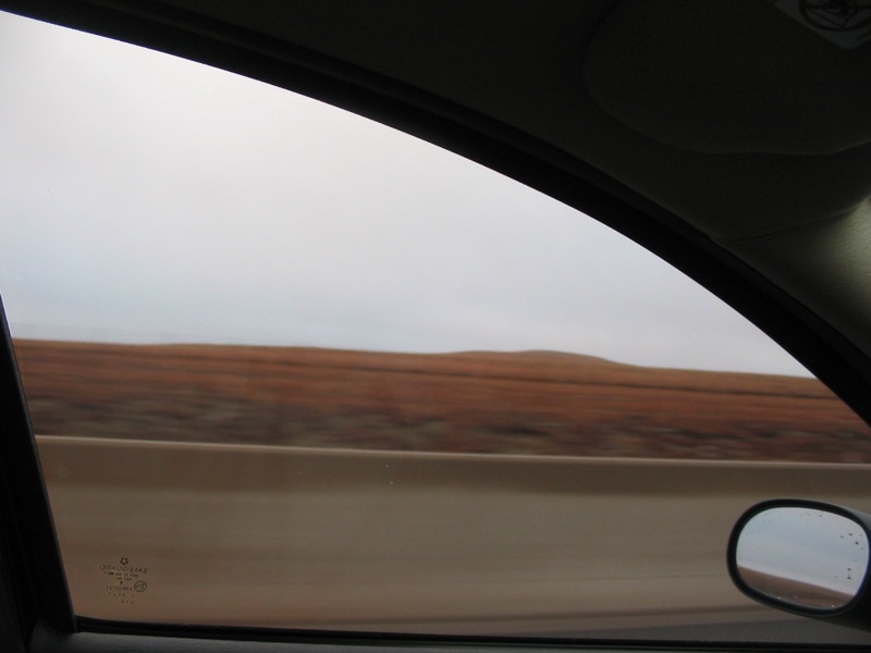 an open car window with a desert in the background