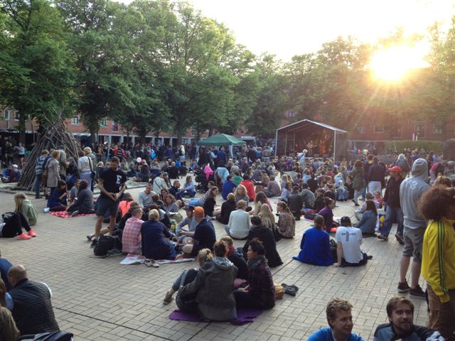 a large crowd of people sitting in the middle of a plaza