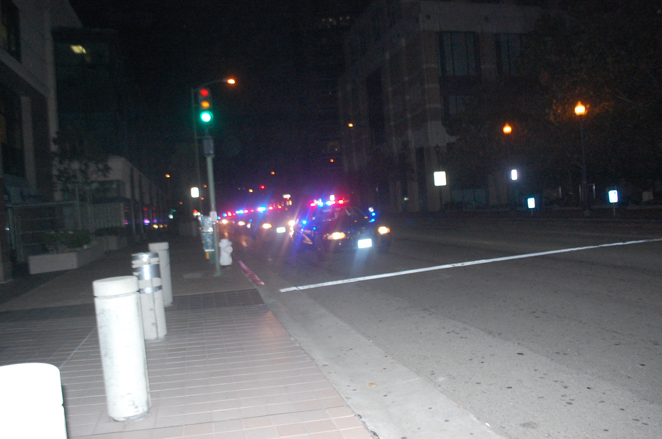 a city street at night with police cars on the street