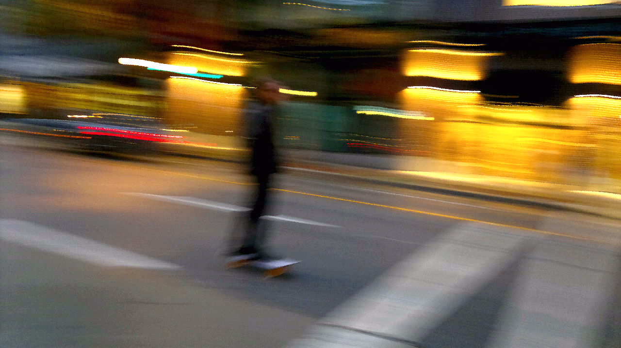 a person is skateboarding in the city street at night
