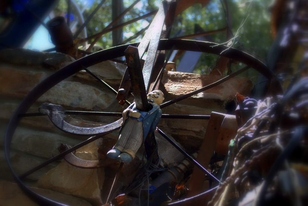 a wooden wheel with a man holding it in his hands