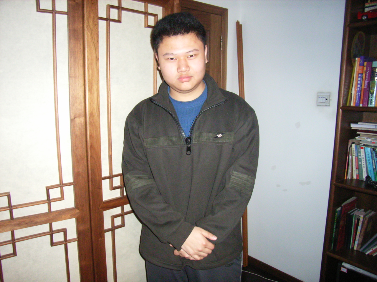 a man is standing in front of a book shelf