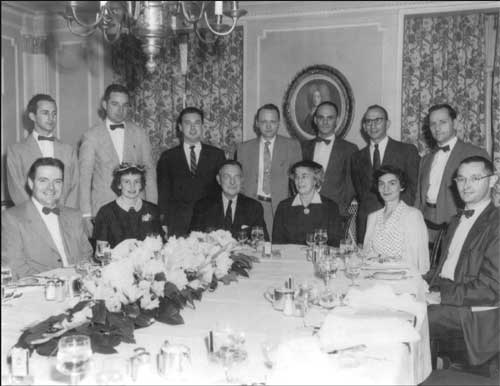 a group po of men and women at a formal dinner