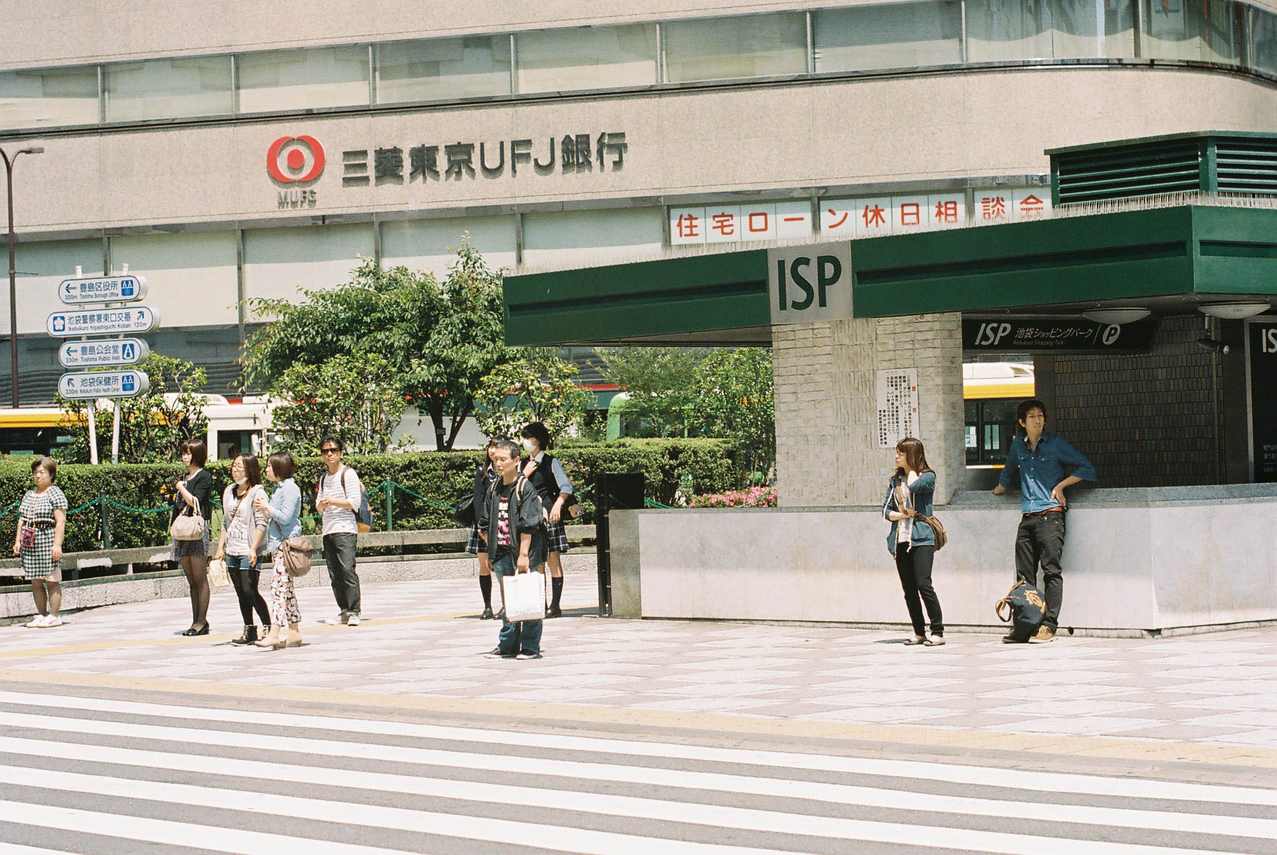 several people are walking around on a city street