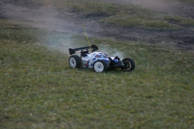 a miniature racing car is spinning on grass