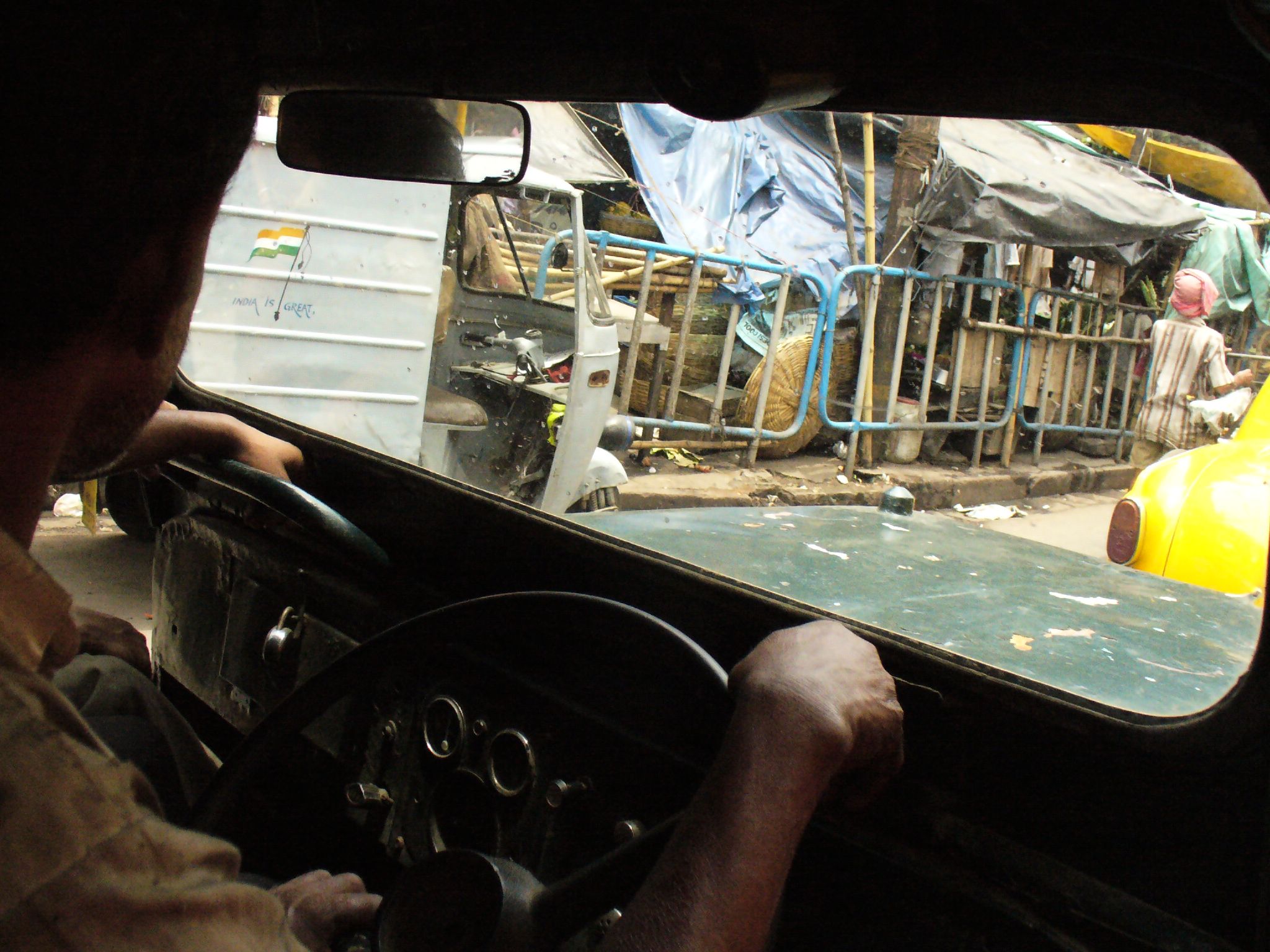 a man driving a car near a blue truck and other items