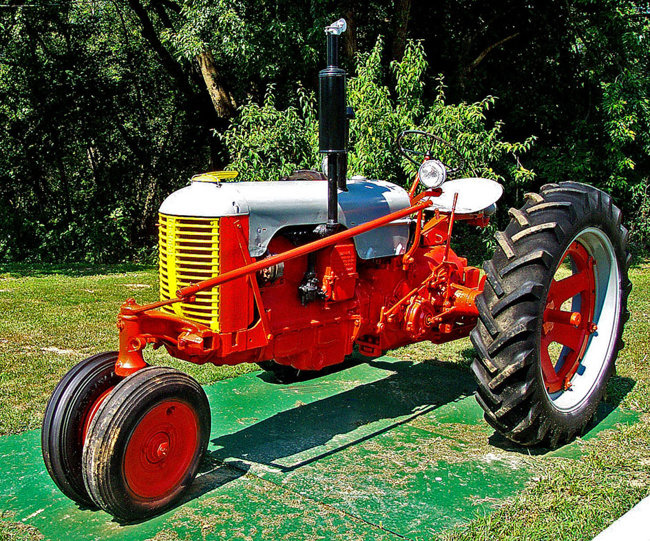 an old fashioned red and white tractor is parked
