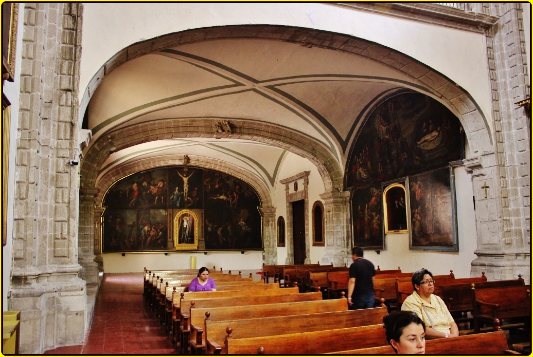 people sitting in rows of pews inside a church