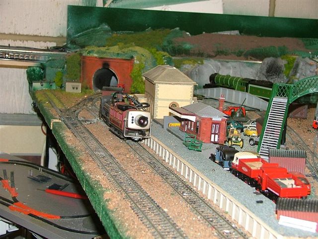 a train is going down the track in a model village