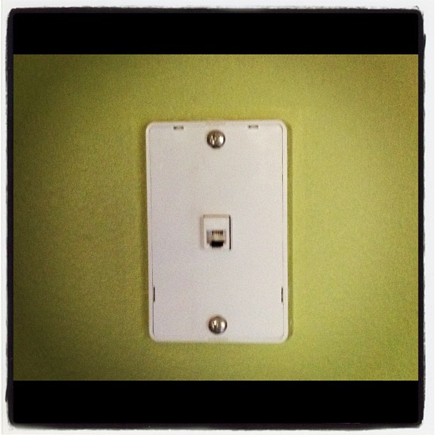 a close up of a light switch on a green wall
