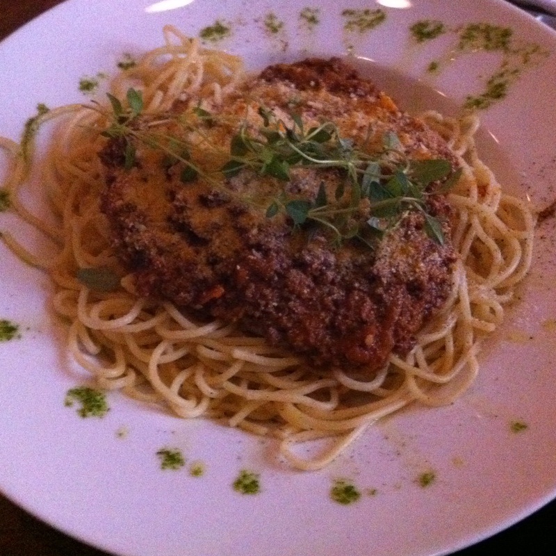 spaghetti with meat on top, served with herbs