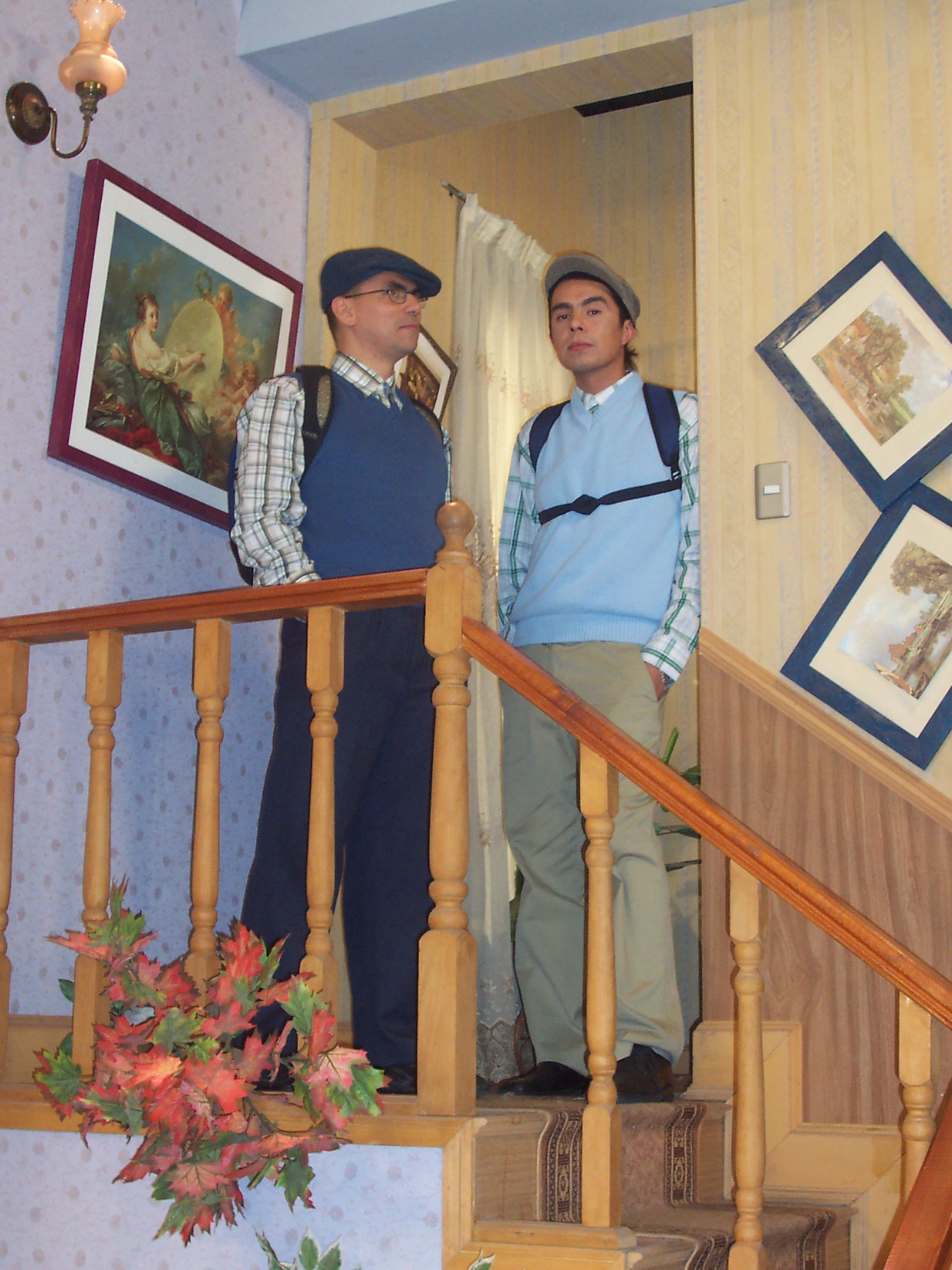 two men are standing on a stairs in a home