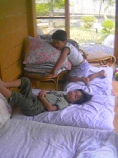 two boys lie on the bed in an open house