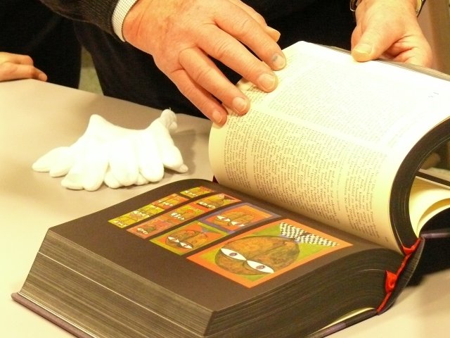 a man in a black shirt a book and white gloves