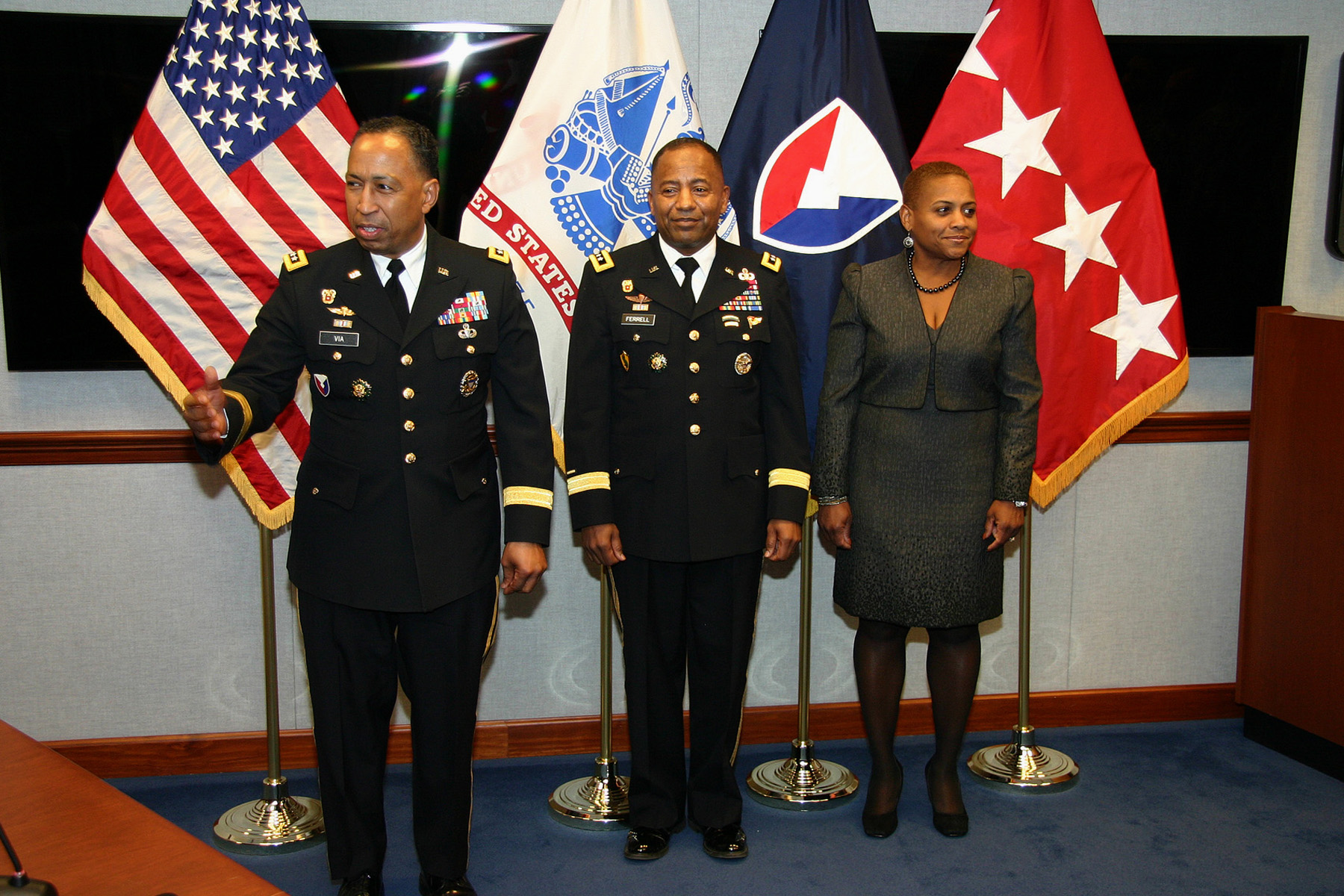 several people in military uniform standing beside three american flags