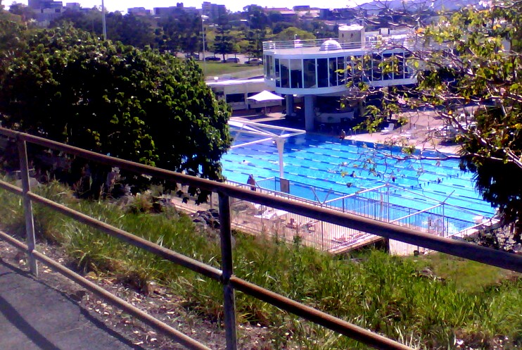 a view from the top of a fence shows a swimming pool