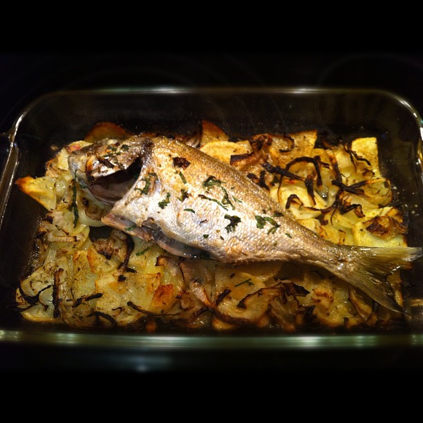 cooked fish is in an acroscent dish on the table