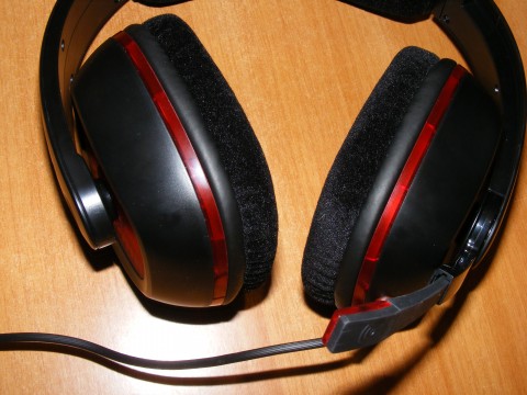 a close - up s of the red and black headphones on a wood table