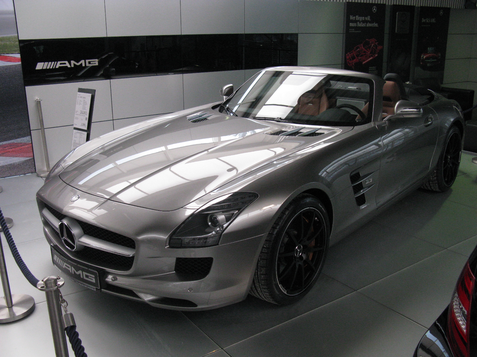 the large silver mercedes sports car is in the display room