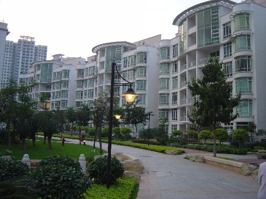 a road surrounded by building with green grass in the middle