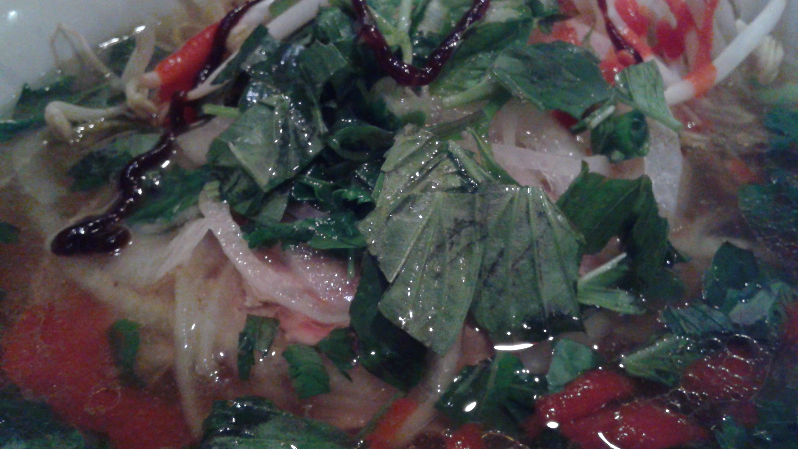 a close up view of vegetables in soup with sauce