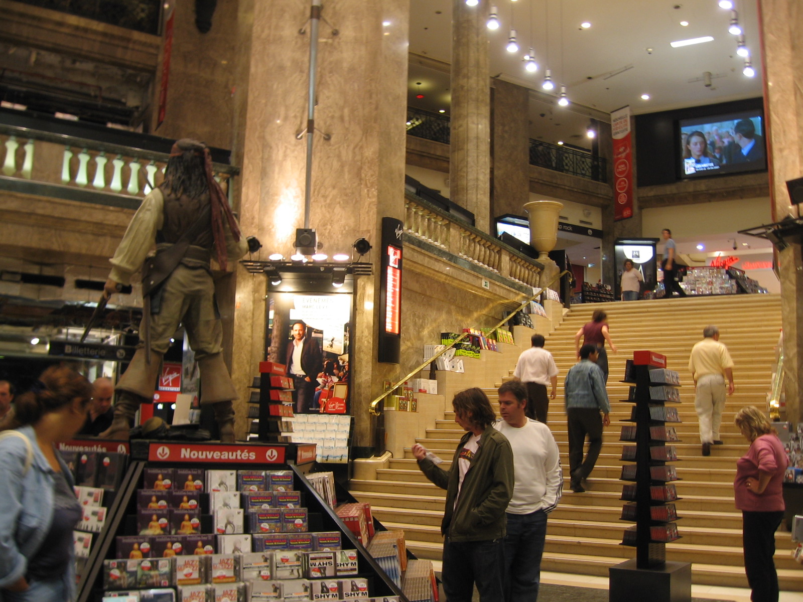 a crowd of people walk around inside a building