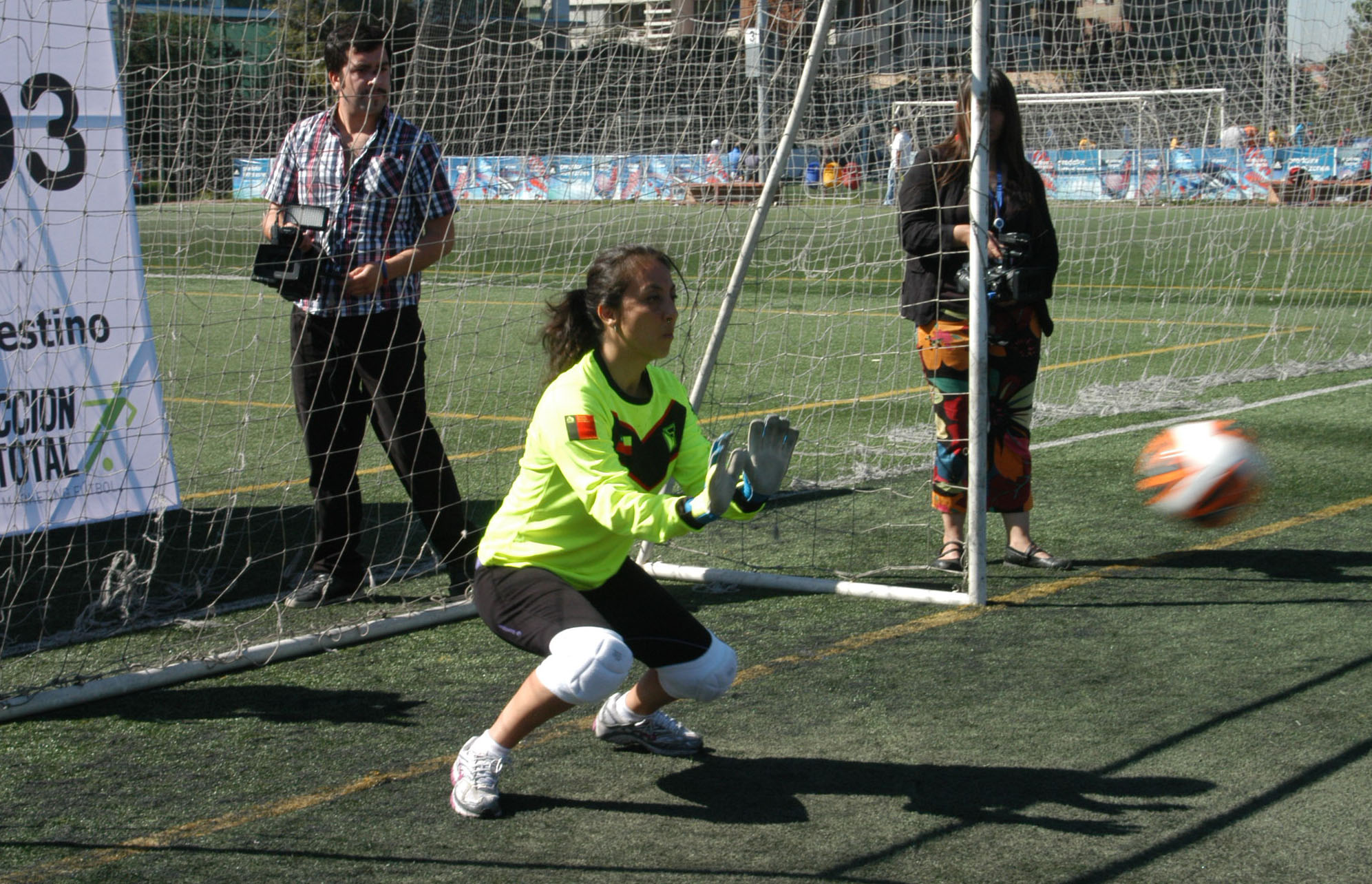 children playing soccer on an outdoor field with spectators