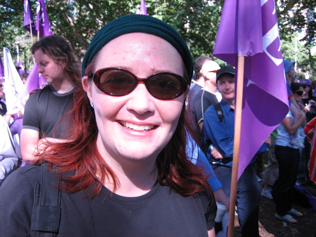 woman with dark glasses and green beret smiling