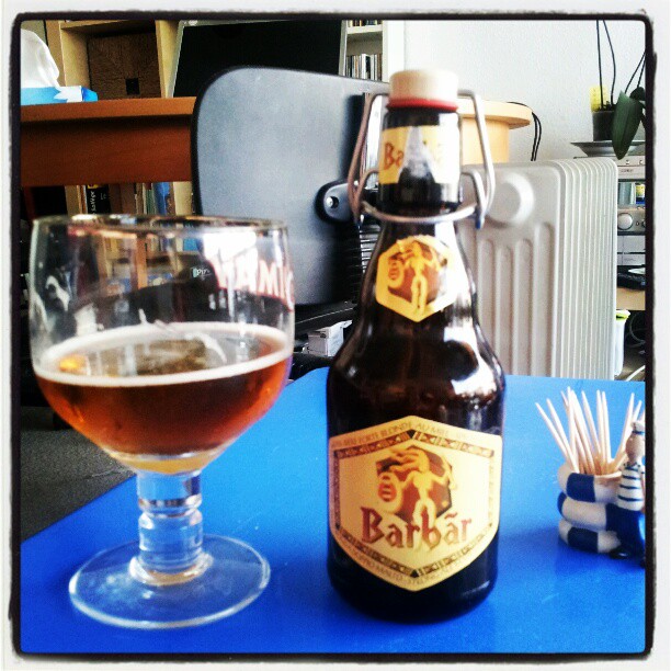 a bottle of beer sitting next to a glass