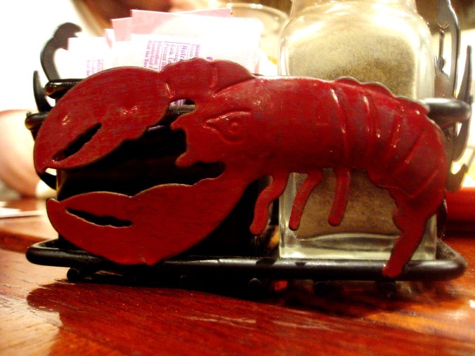 a plastic lobster model on a small desk