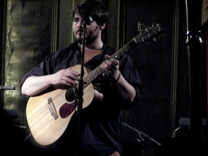 a man with a beard is playing a guitar