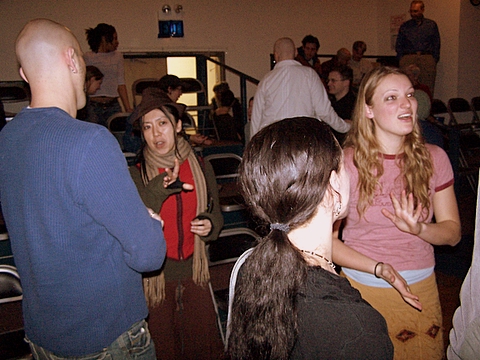 a group of people standing around talking to each other