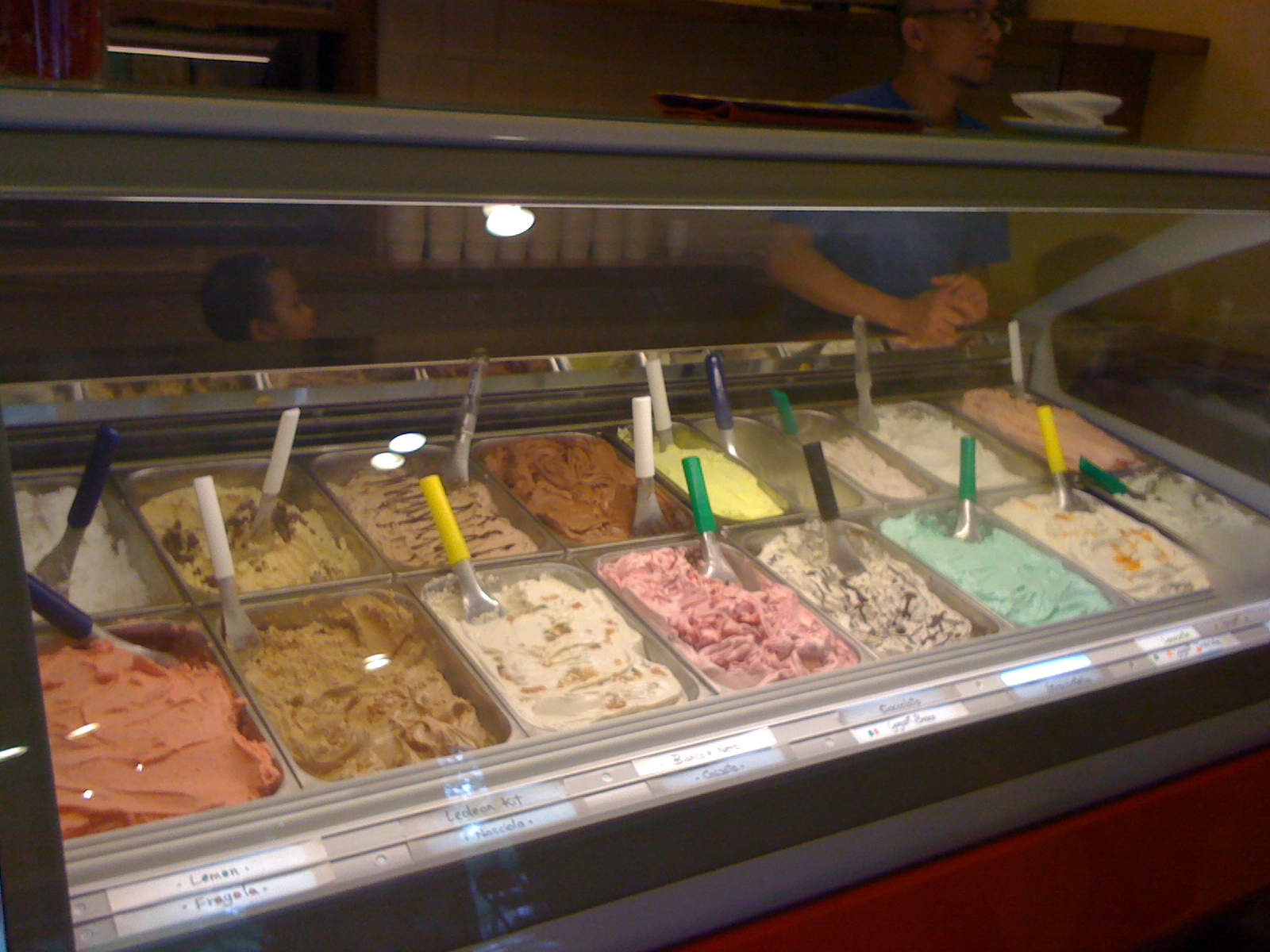 a person serving up an assortment of different types of ice cream