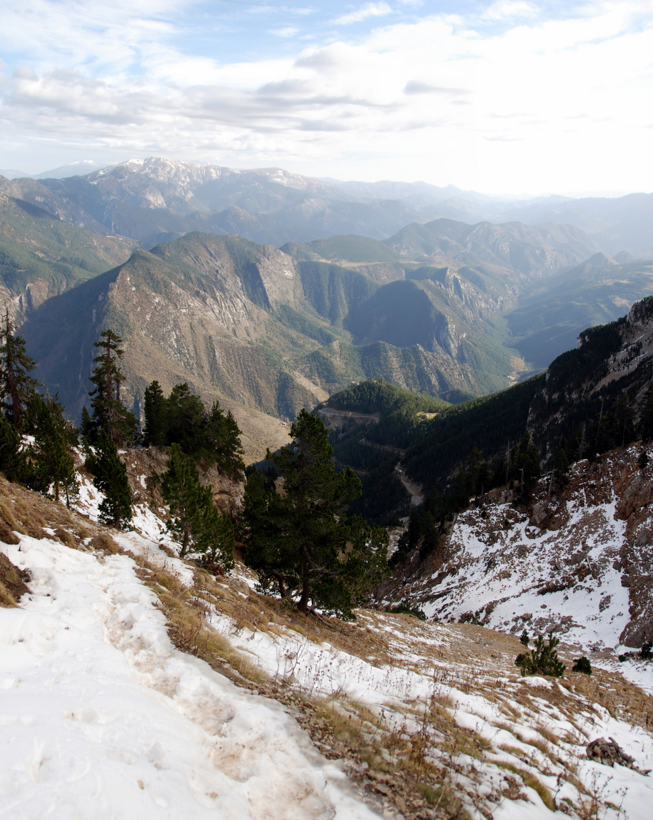 a trail on the side of a mountain near mountains