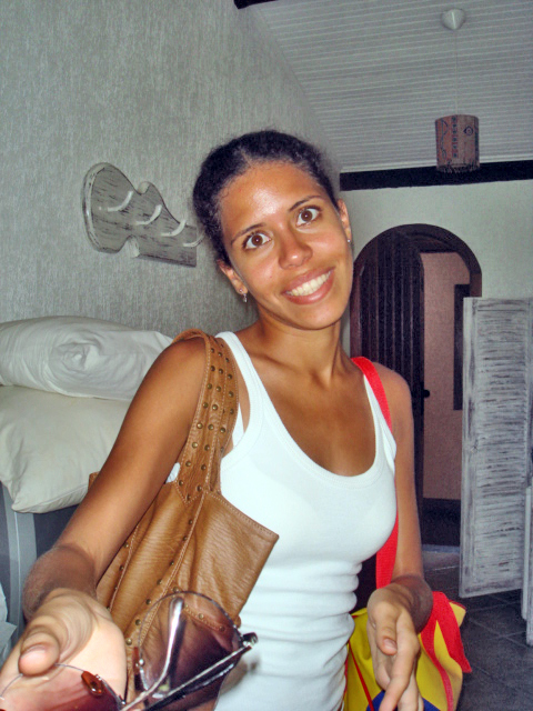 a woman wearing a white tank top carrying bags