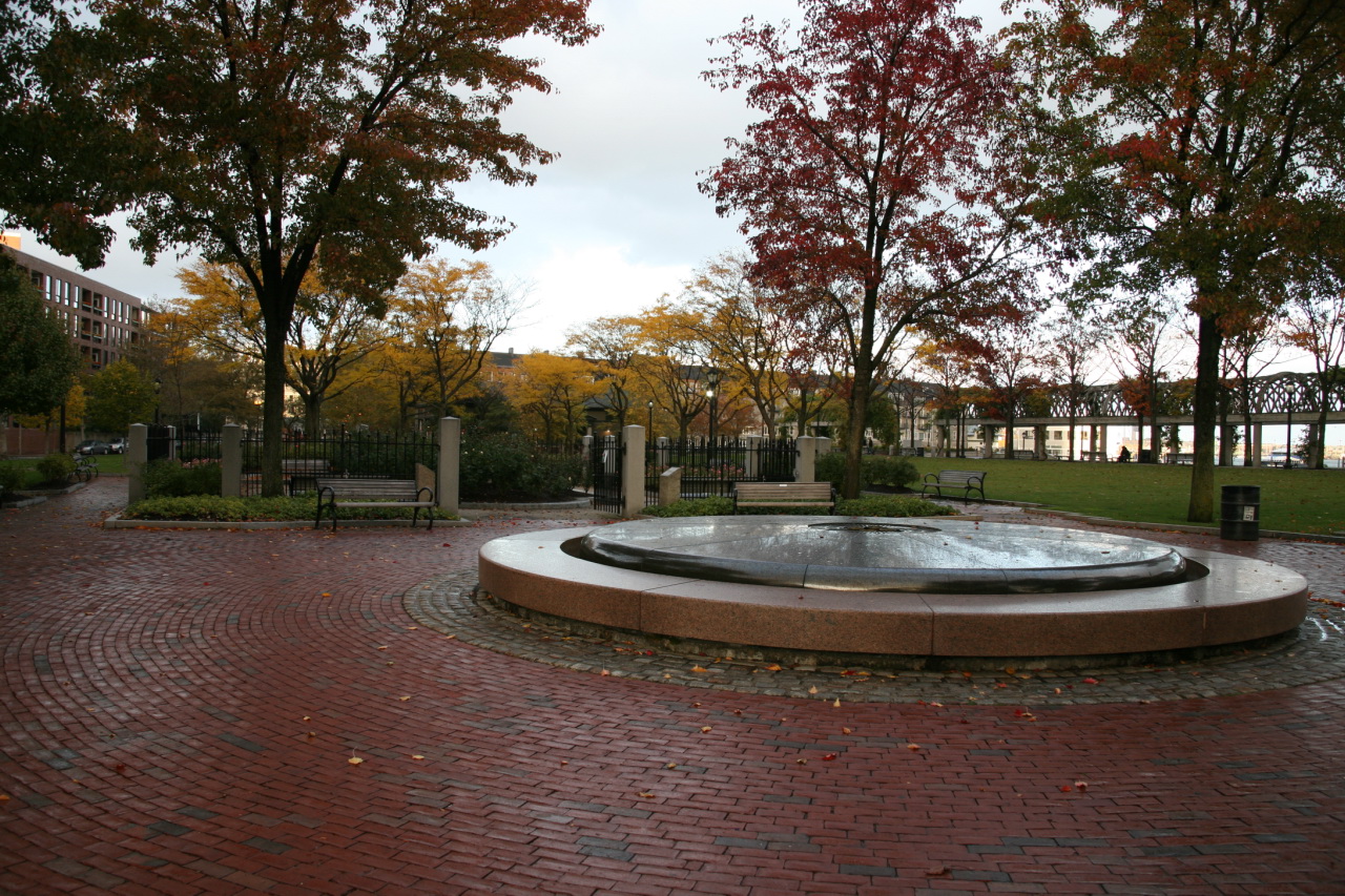an outdoor fountain surrounded by bricks and trees