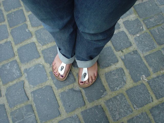 a persons feet wearing flip flops and sandals