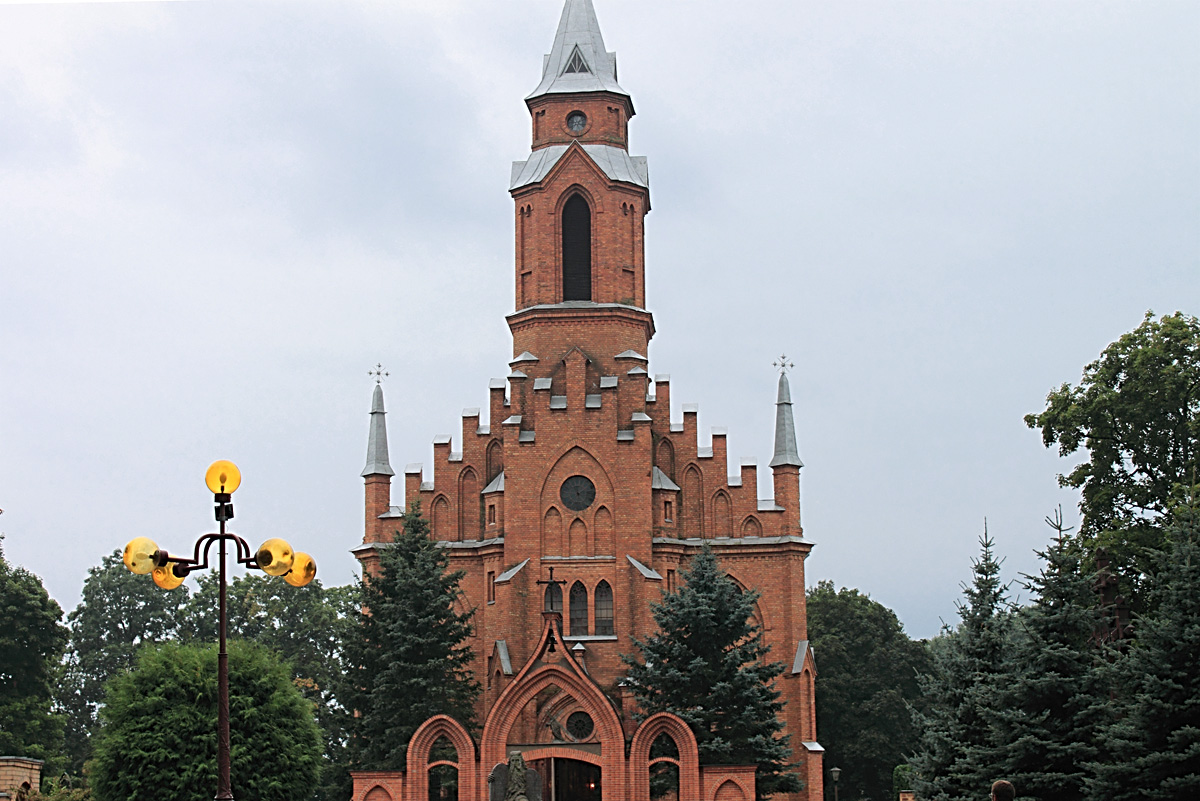 an old church sits in a park with a clock tower