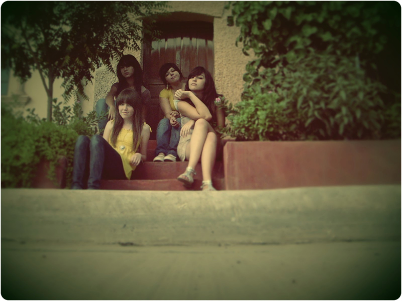 five young ladies are seated on a set of steps