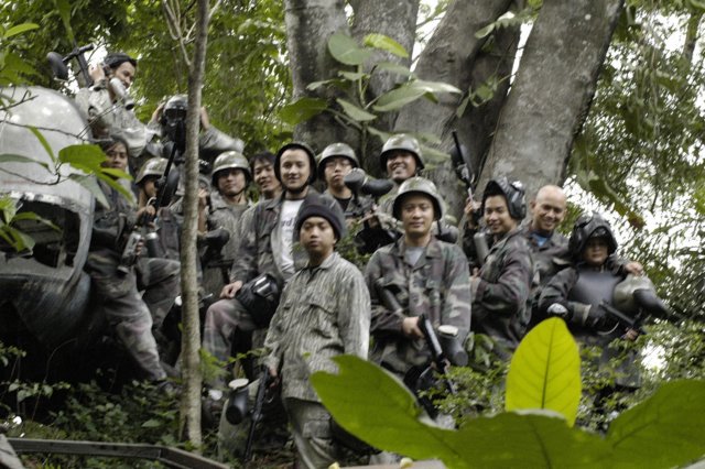 many people in military gear are riding in a forest