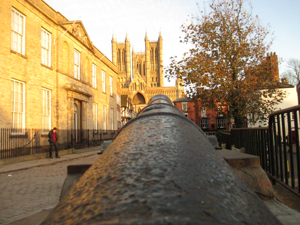 a large cannon in the street next to buildings