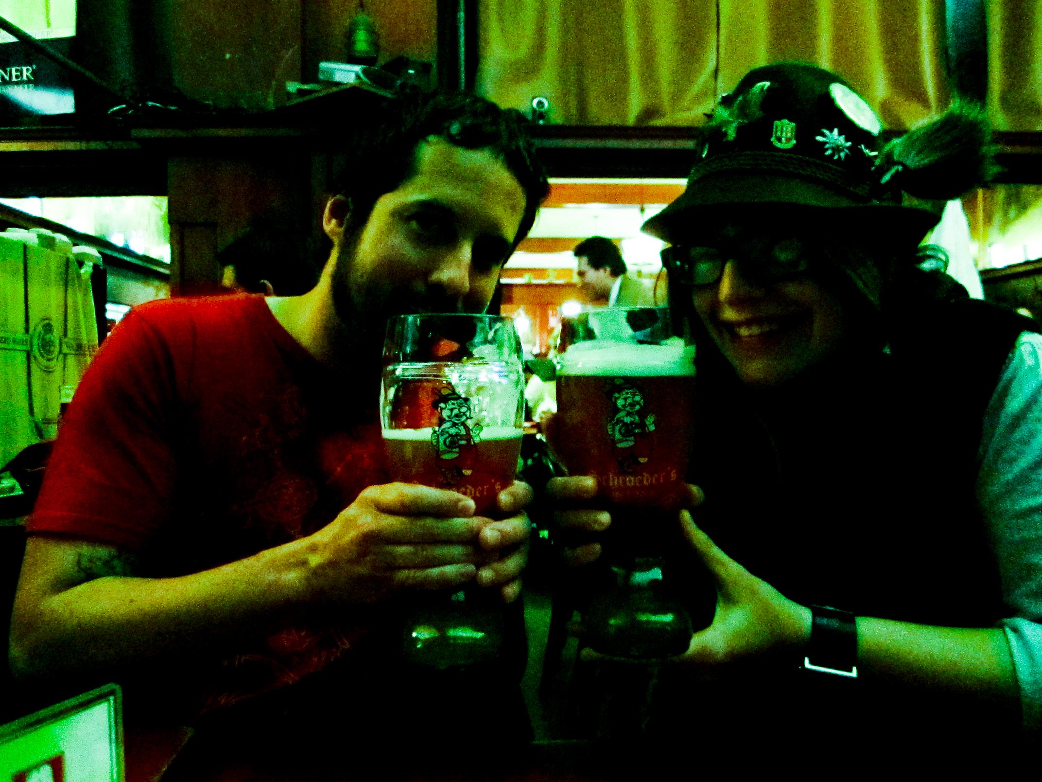 two people wearing pirate hats toasting with beer