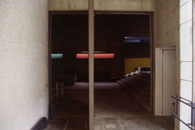 the hallway is in an empty building, in the center is a chair with a long tail