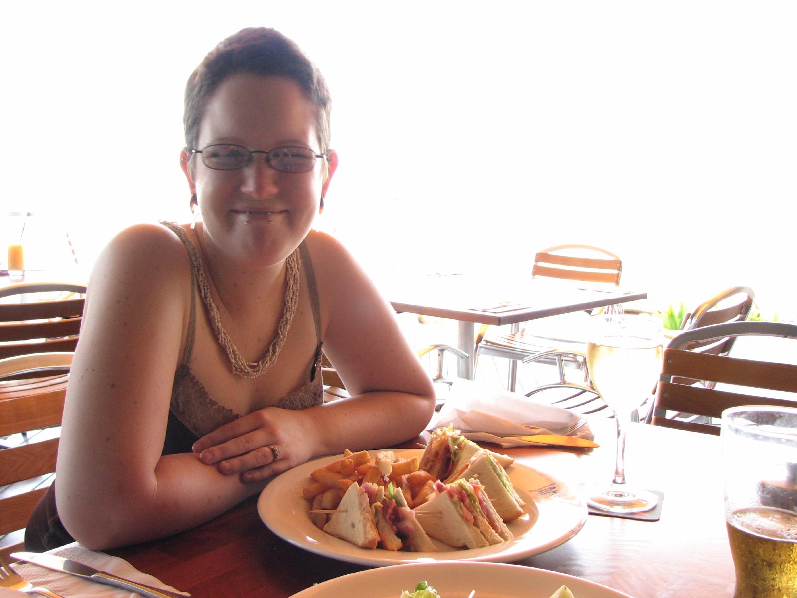 a woman smiling at the camera, with food on a plate