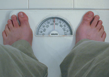 person standing on the scale in front of white tile