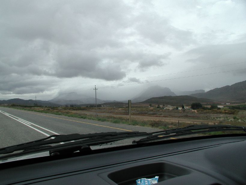 there is a small road in the distance with the clouds