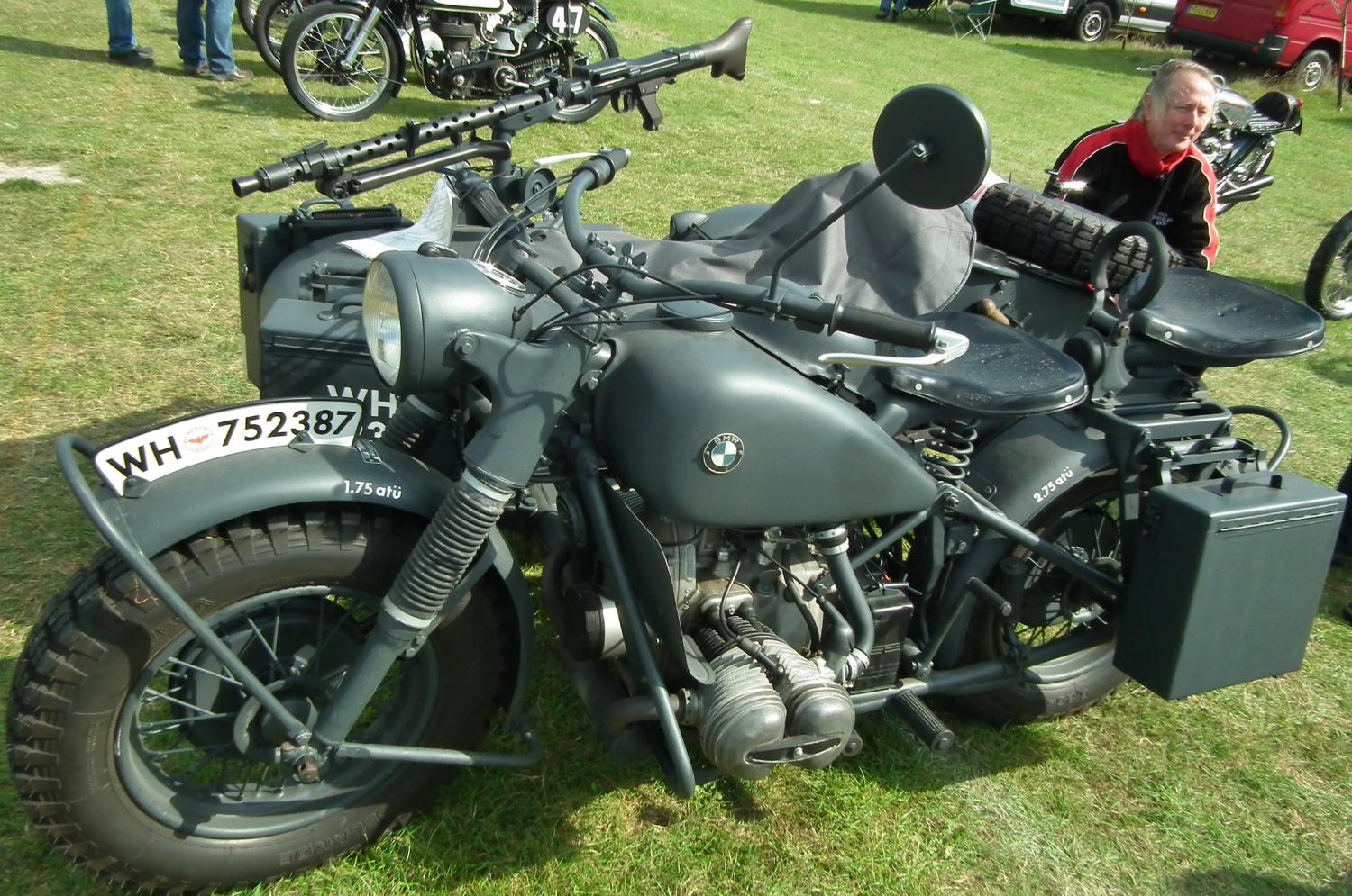 a man sits in a seat on top of a parked motorcycle