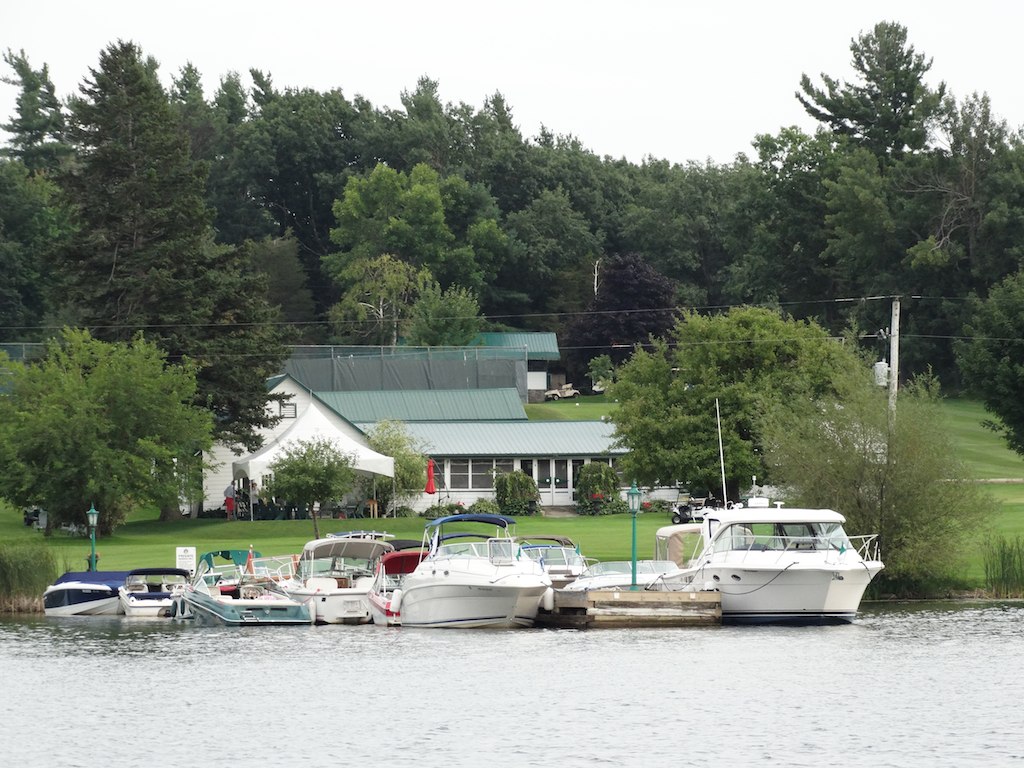 several small boats parked at the dock in front of a house