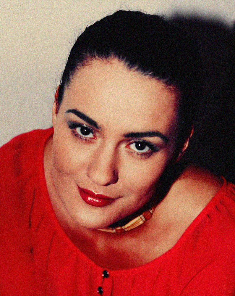 a woman with a red top smiling for the camera
