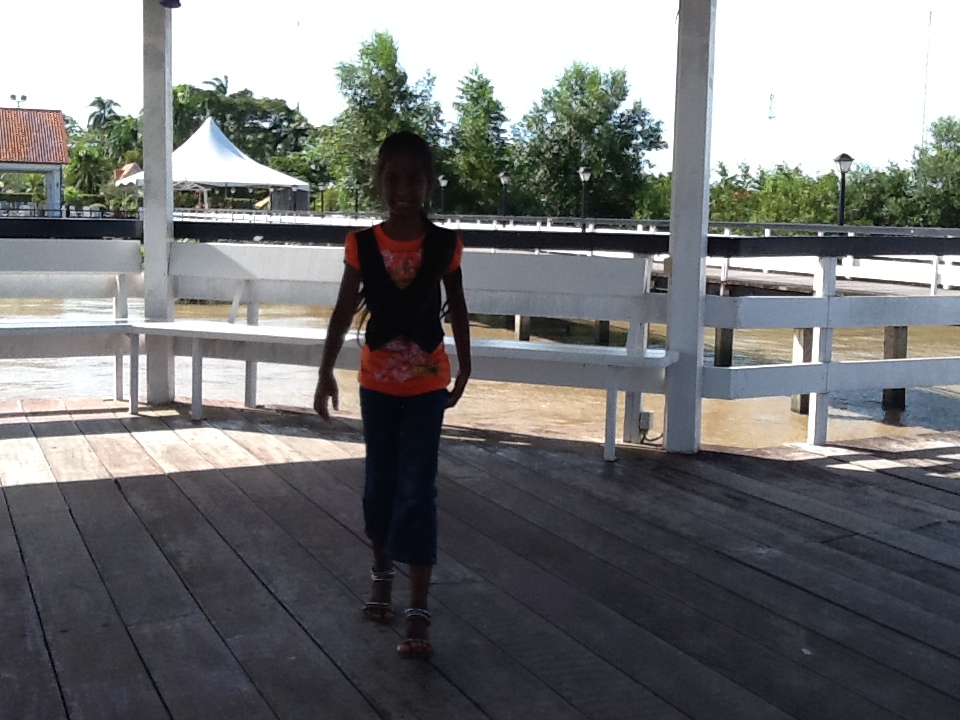 the girl is walking in the shade on the deck